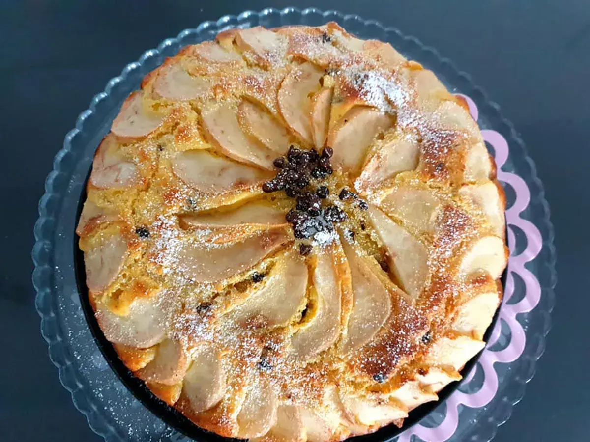 Torta ricotta e pere, ricetta originale napoletana, con fette di pera disposte a raggiera e spolverata di zucchero a velo.