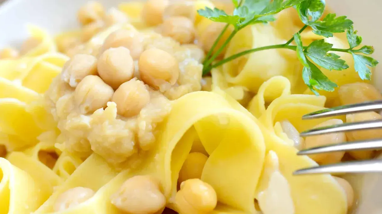 Ciceri e tria, un piatto pugliese con pasta fresca e ceci, guarnito con prezzemolo.