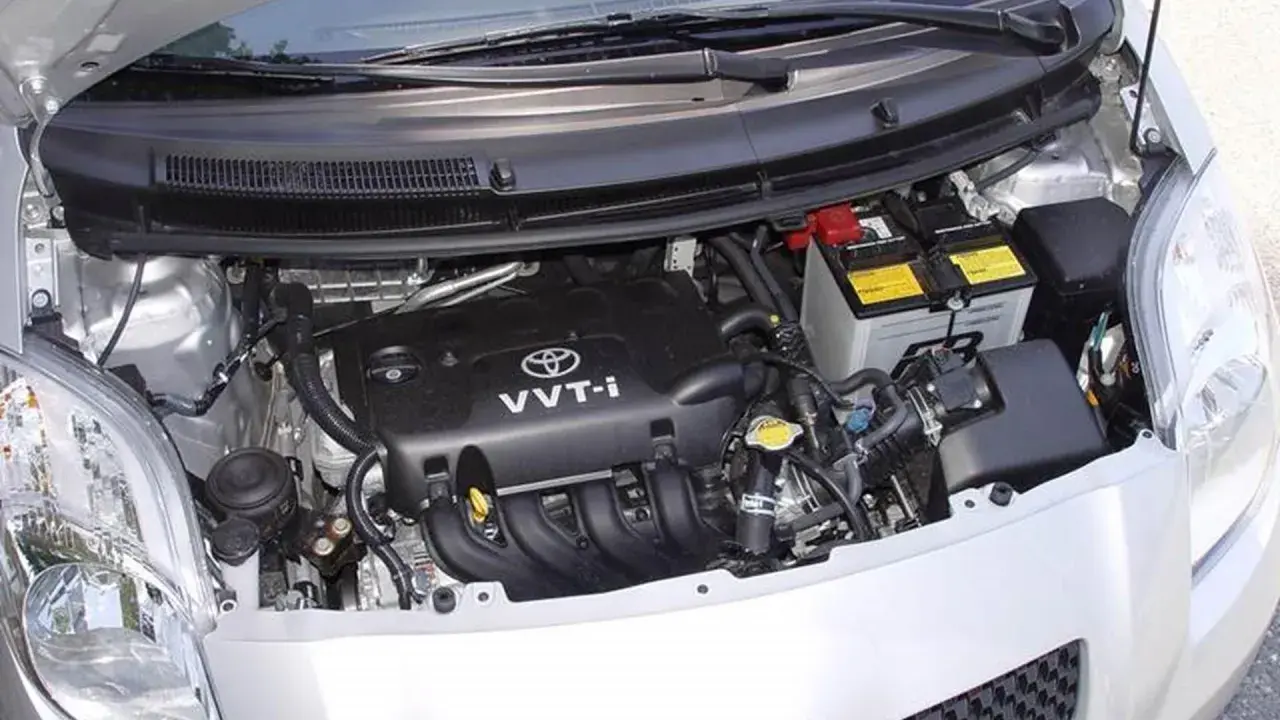 Silnik Toyoty Yaris II z widocznym akumulatorem i elementami osprzętu.