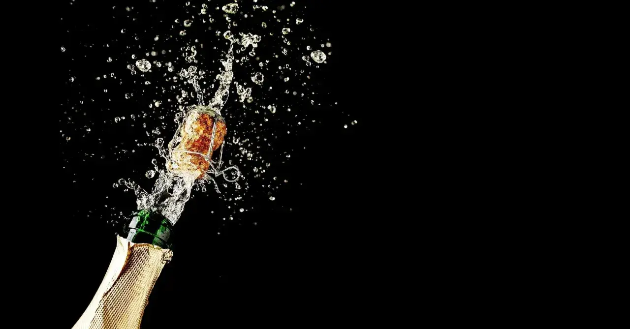 Champagnerkorken spritzt mit Flüssigkeit aus einer Flasche. Perfekt für den Moment, wenn man Champagner lagern und dann genießen möchte.