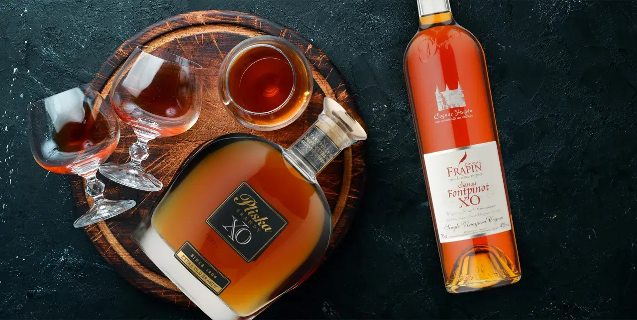 Butelka i kieliszki z bursztynowym brandy. To jest co to jest brandy - szlachetny trunek.