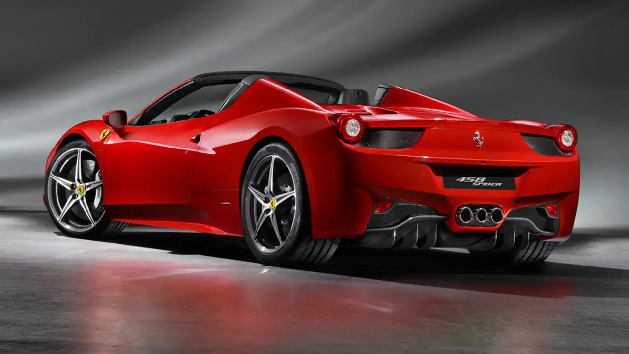 Czerwony kabriolet Ferrari 458 Spider z opuszczonym dachem, prezentujący swoje sportowe linie i potężne tylne światła.