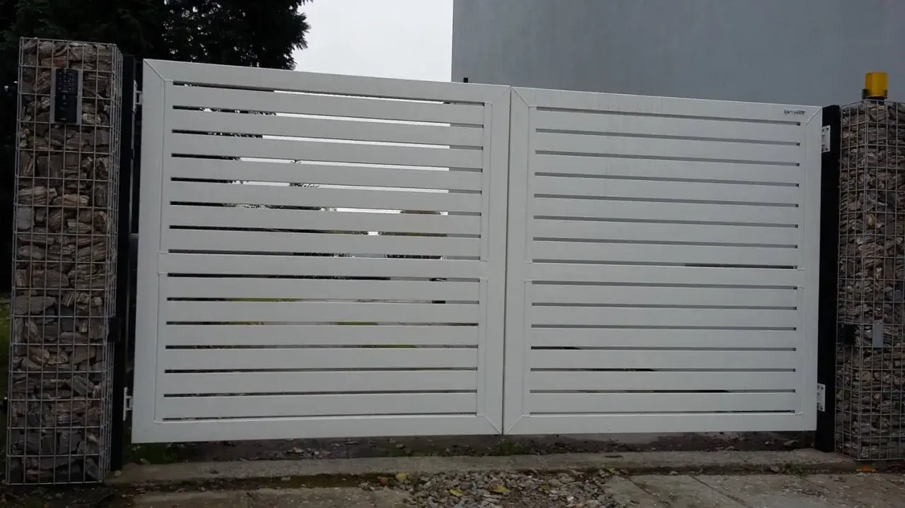 Nowoczesna, biała brama z poziomymi lamelami. Po lewej stronie widoczny enkoder, co to za urządzenie?