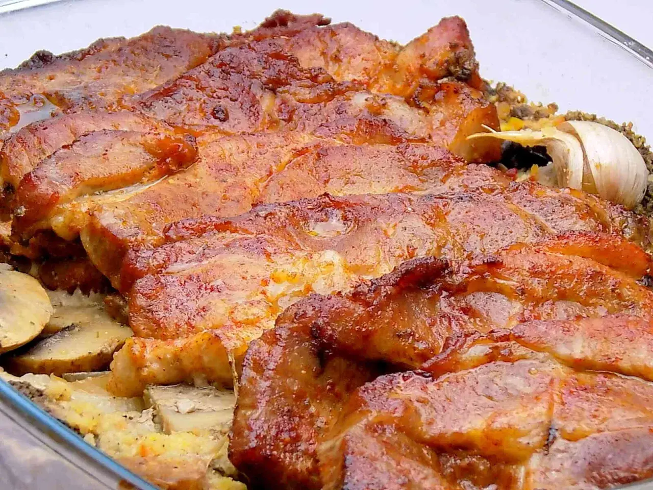 Soczysta karkówka z pieczarkami i cebulą z piekarnika, pachnąca czosnkiem. Idealna na obiad.