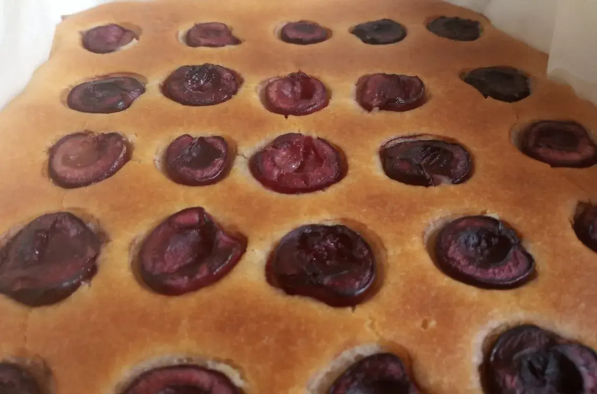Puszyste ciasto z czereśniami, z widocznymi połówkami owoców zatopionymi w złocistym cieście. Idealne na letnie popołudnie.