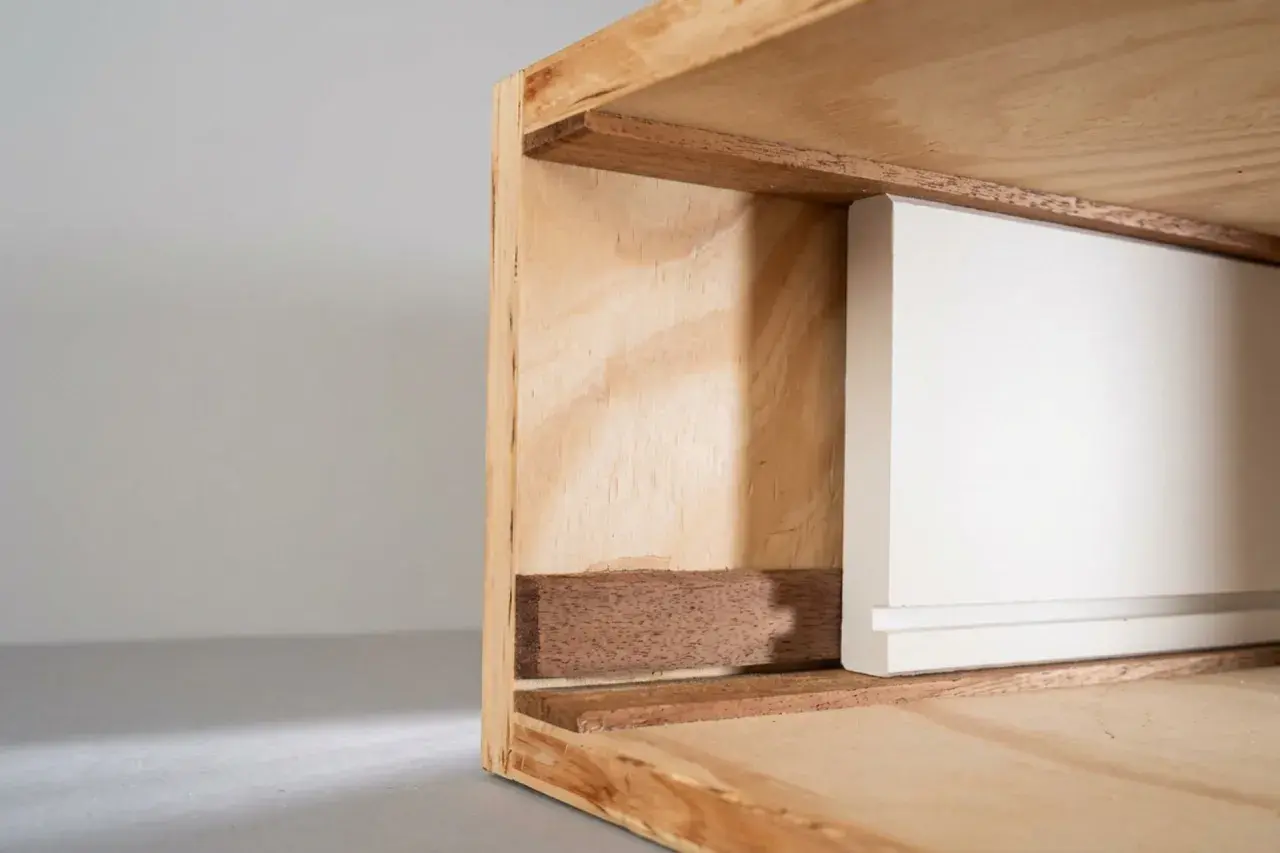 Detailaufnahme einer weißen Schubladenfront, die in einen Holzrahmen gleitet. Perfekt, wenn Sie eine Schublade selber bauen möchten.