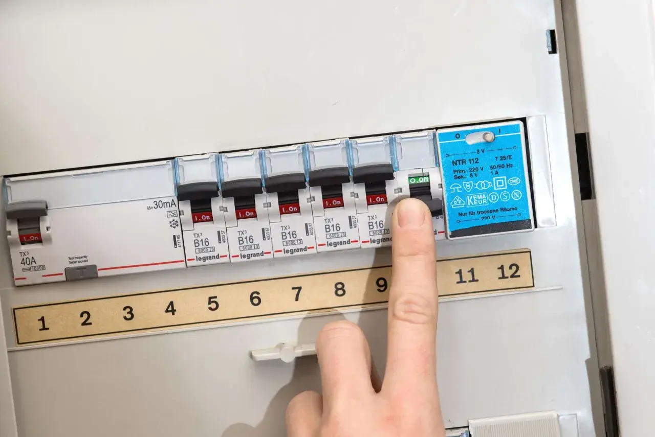 Finger schaltet Sicherung aus. So kann man eine defekte Sicherung erkennen.