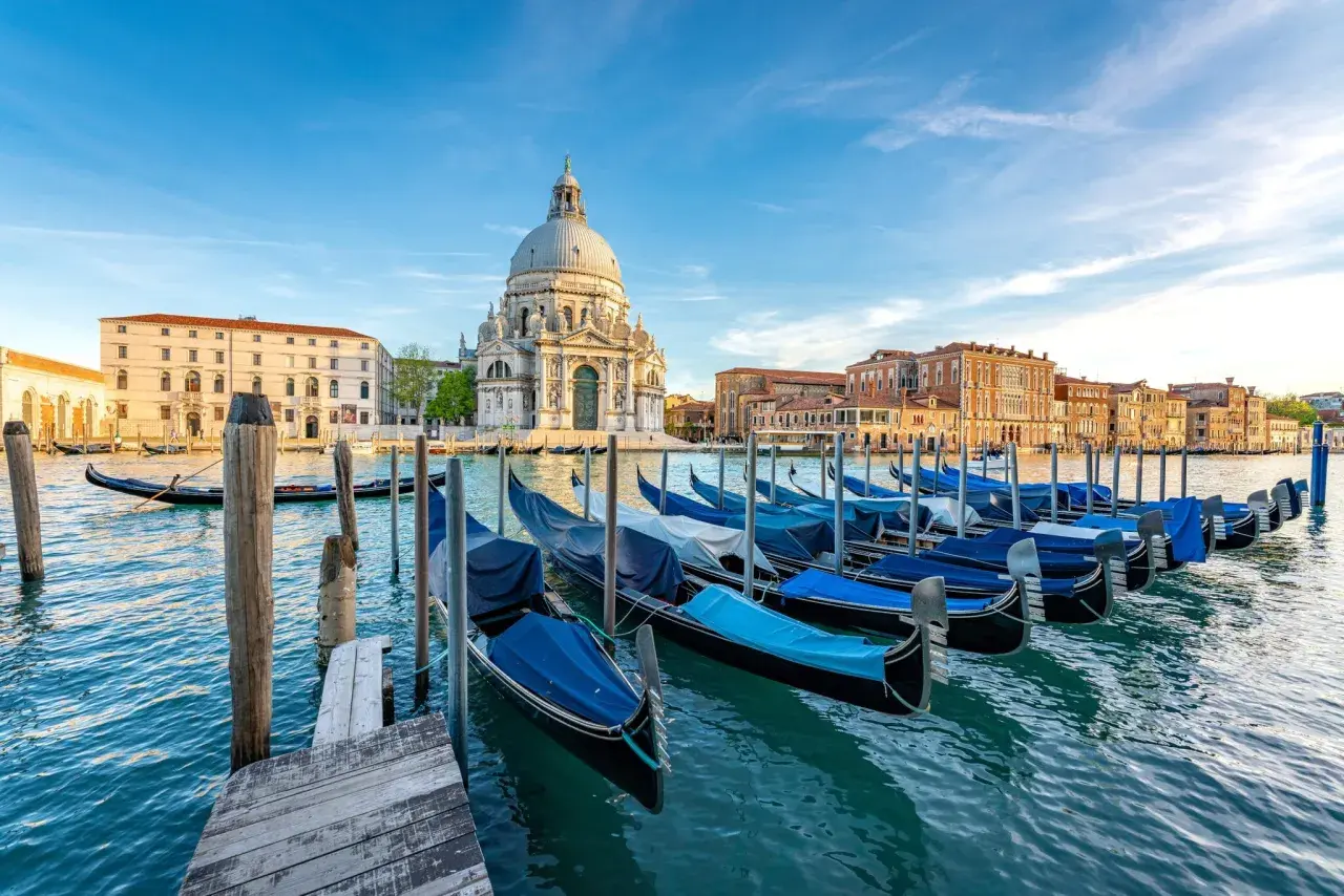 Gondeln am Kai vor der Basilica di Santa Maria della Salute. Entdecken Sie Venedig Geheimtipps abseits der Touristenpfade.