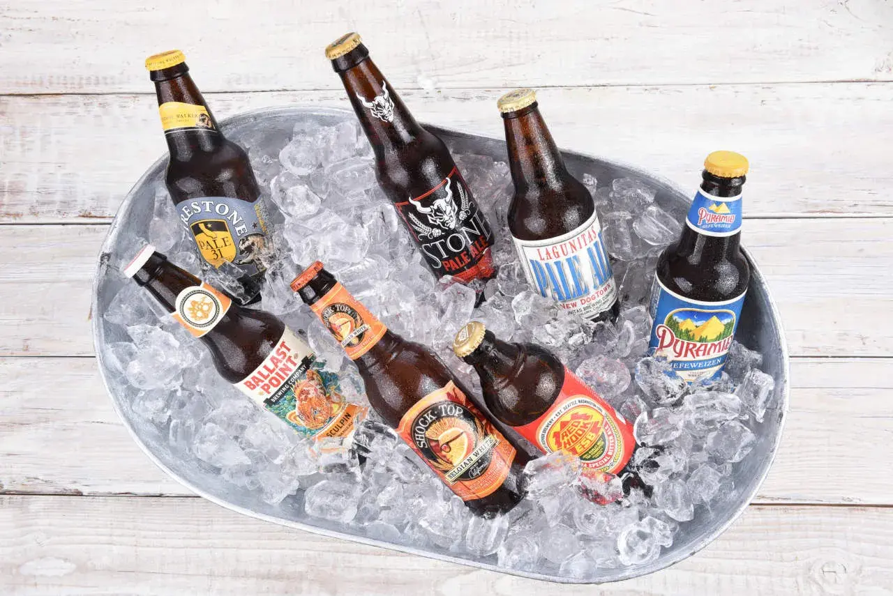 Secchio di birre in ghiaccio, tra cui una Stone IPA Pale Ale, Lagunitas Pale Ale e Ballast Point Sculpin.