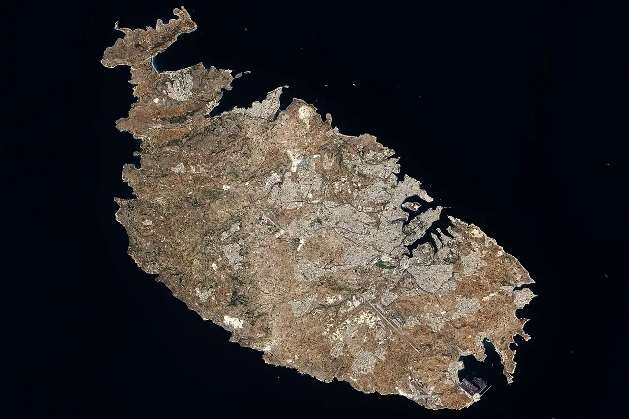 Widok satelitarny Malty, ukazujący gęsto zaludnione obszary miejskie i porty. Widać, ile ludzi ma Malta, skupionych wzdłuż wybrzeża.