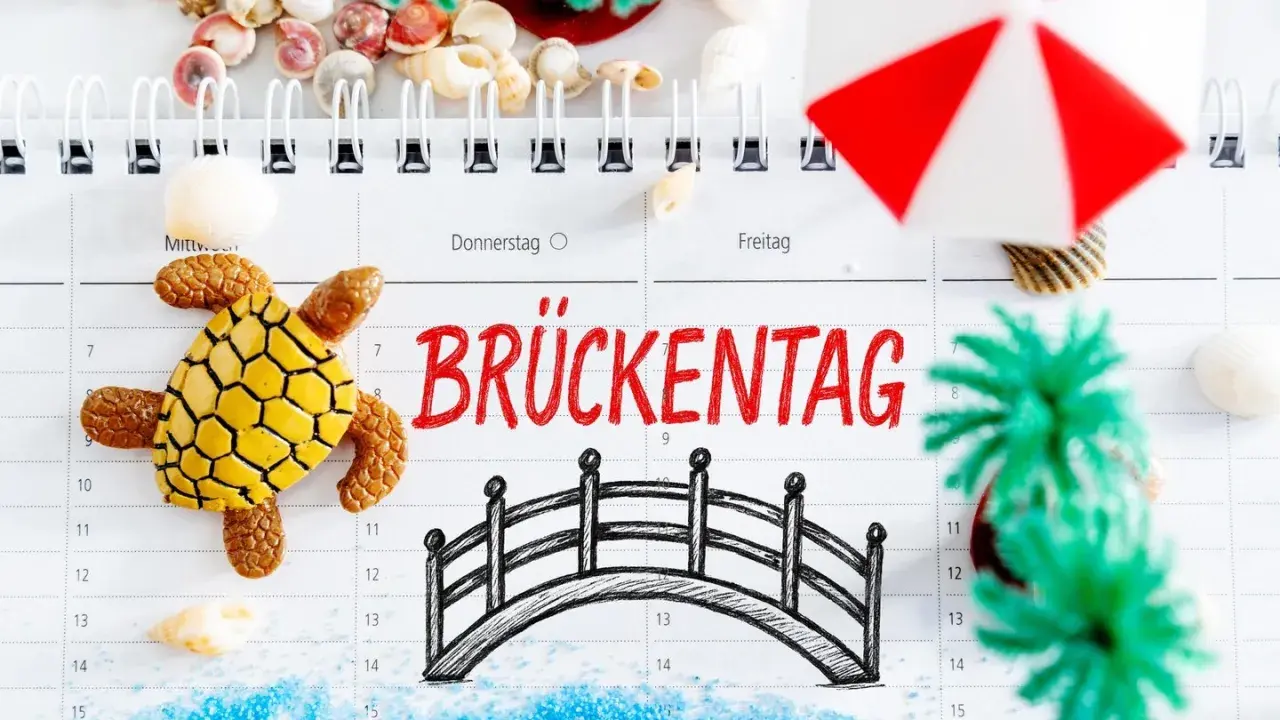 Urlaubsplanung 2026: Ein Brückentag mit Schildkröte, Brücke und Muscheln lädt zum Träumen ein.