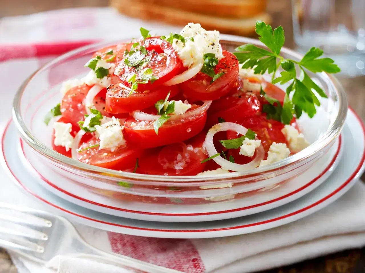 Frischer tomatensalat mit feta, Zwiebeln und Petersilie, garniert mit Pfeffer und Salz. Ein leichter Genuss.