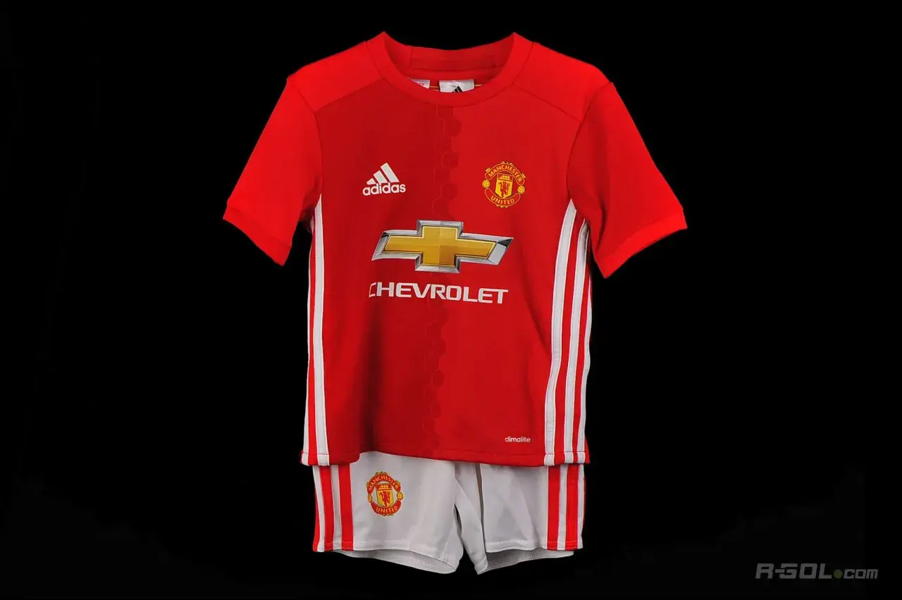 Dziecięcy komplet piłkarski Manchester United: czerwona koszulka i białe spodenki.