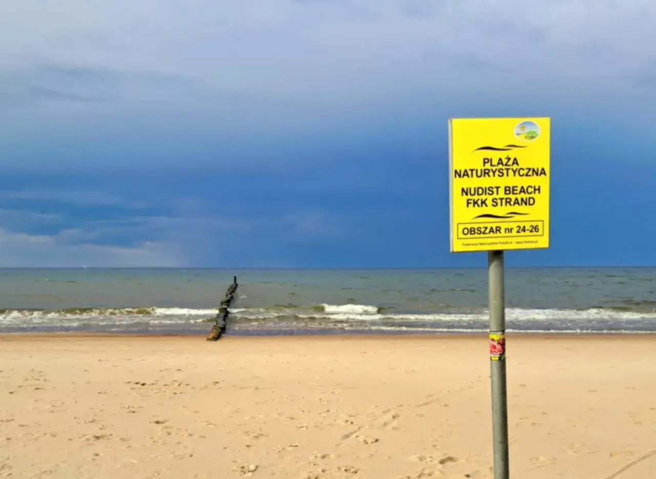 Plaża Chałupy, obszar 24-26, zaprasza na nudystyczny relaks. Spokojne morze i piasek pod błękitnym niebem.