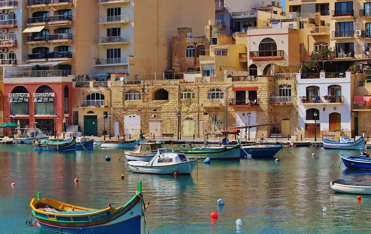 Malta: kolorowy port z łodziami i kamiennymi budynkami. Czy na Maltę potrzebny paszport? Tak, jeśli nie jesteś obywatelem UE.