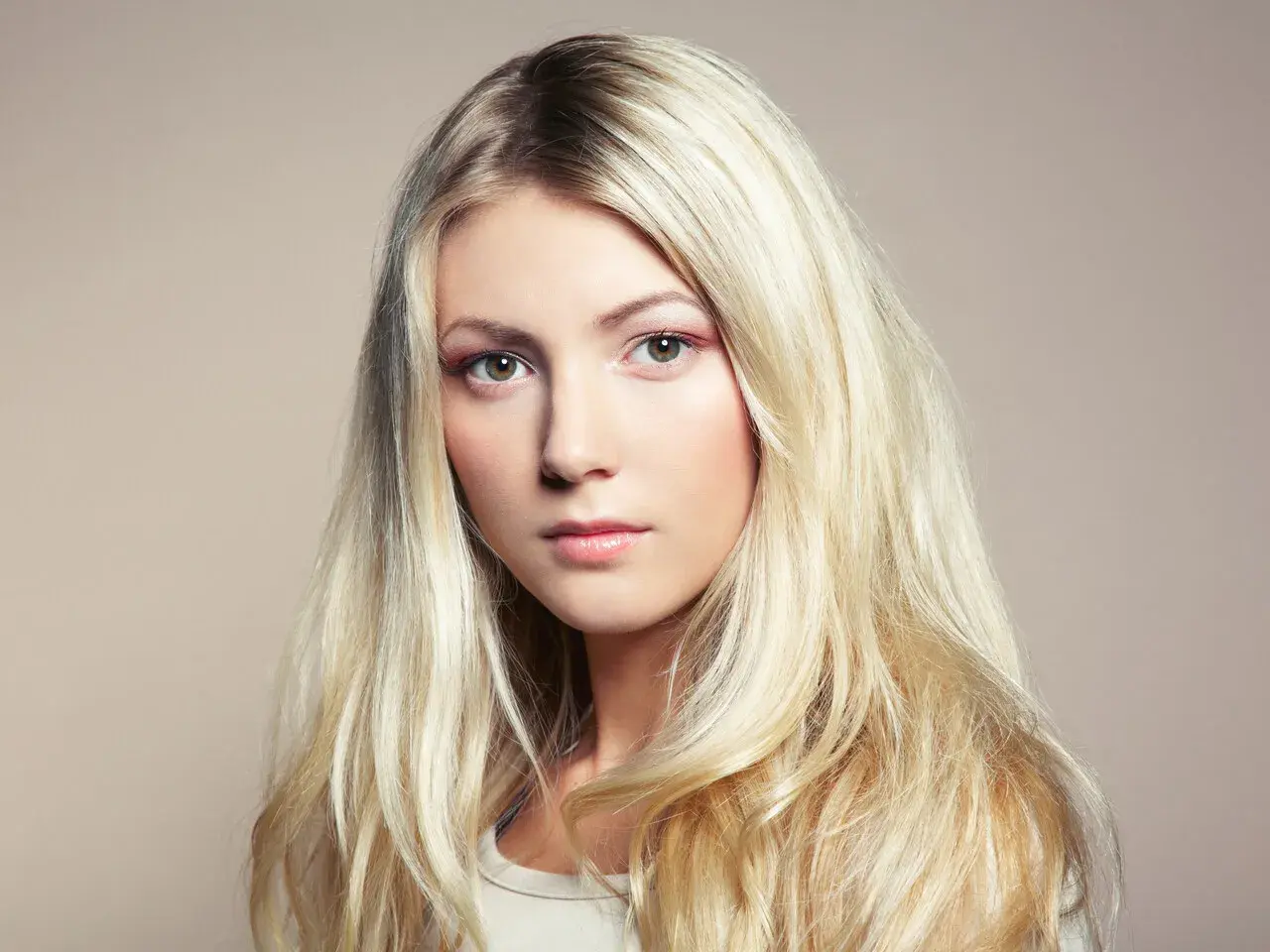 Piękna blondynka z długimi, falowanymi włosami. Poznaj sekrety, jak dbać o blond włosy, by były zdrowe i lśniące.