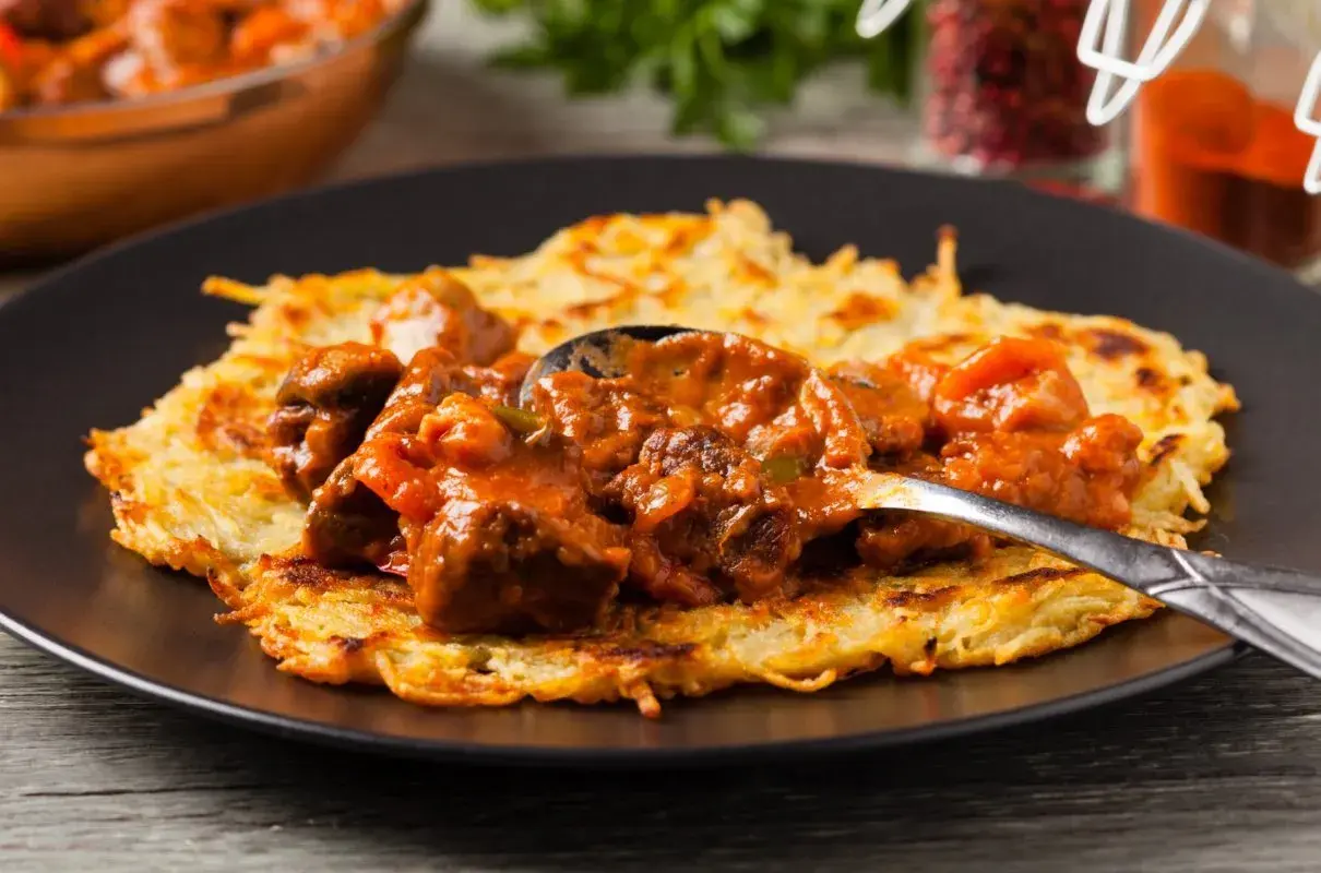 Gulasz do placka po węgiersku, bogaty i aromatyczny, podany na chrupiącym placku ziemniaczanym.