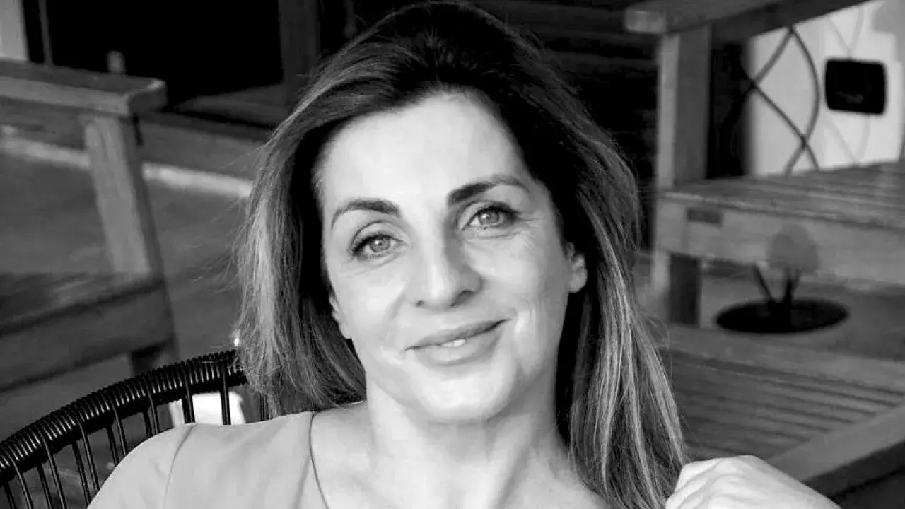 Ritratto in bianco e nero di una donna con capelli castani lunghi e mossi, occhi azzurri e un sorriso leggero. Sembra pensierosa, come se fosse andata a convivere ma non fosse felice.