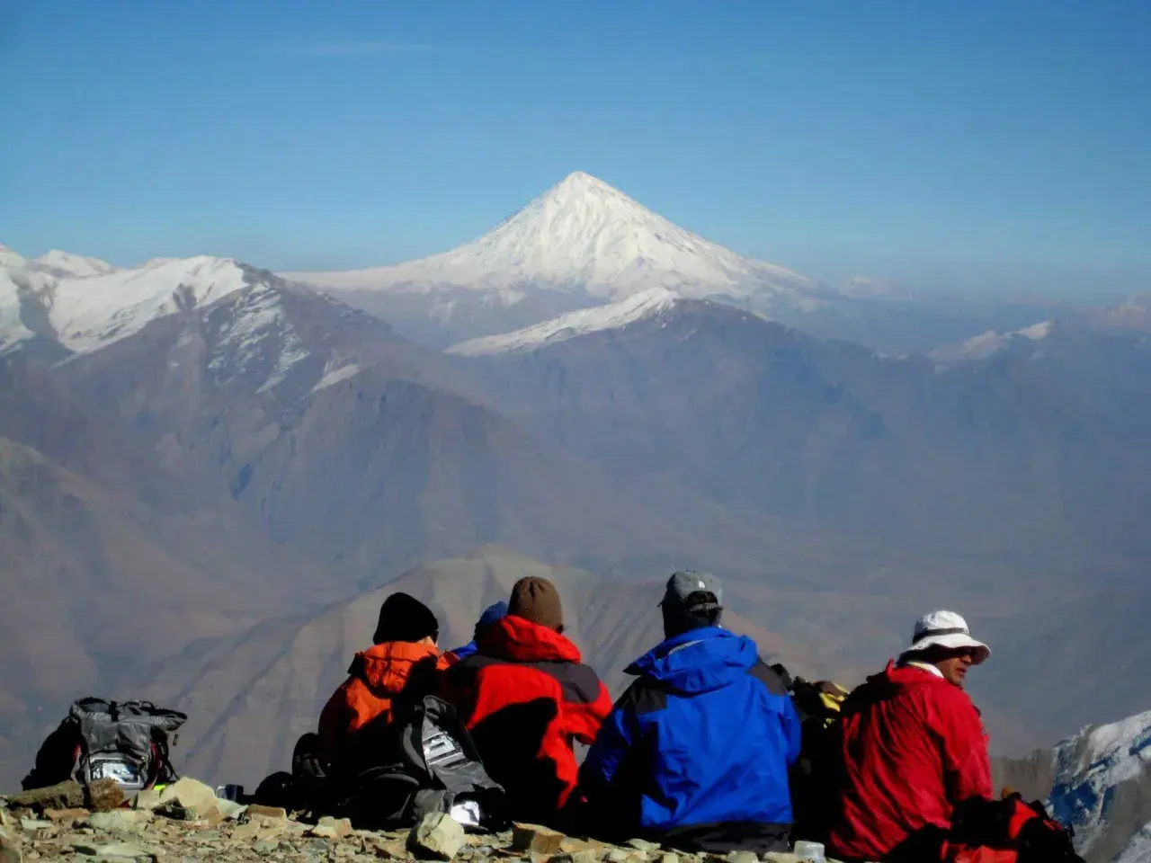 Vier Wanderer blicken auf das majestätische Demavend-Gebirge im Iran.