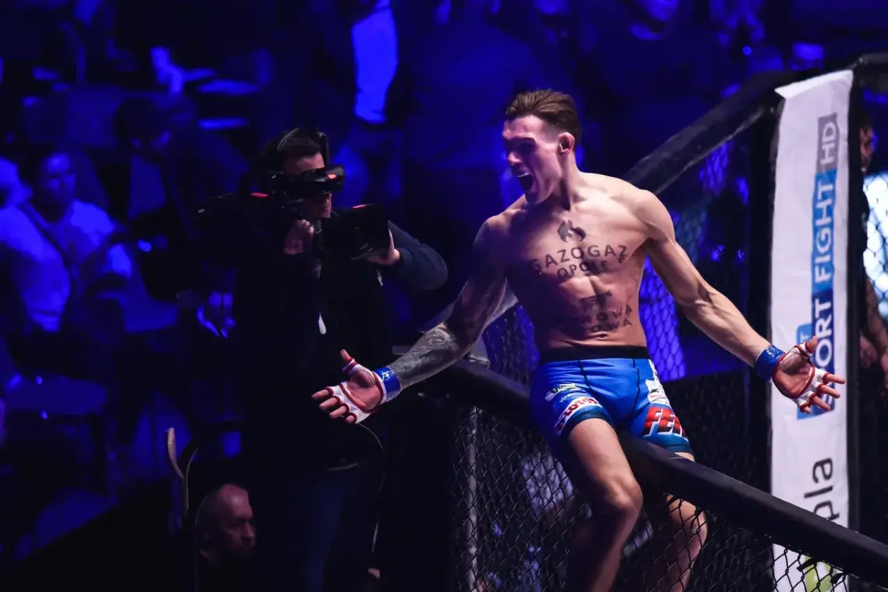 Zawodnik MMA świętuje zwycięstwo, a kamera dokumentuje emocje. To z pewnością jeden z tych momentów, które zapadają w pamięć, gdy śledzimy ksw wyniki.
