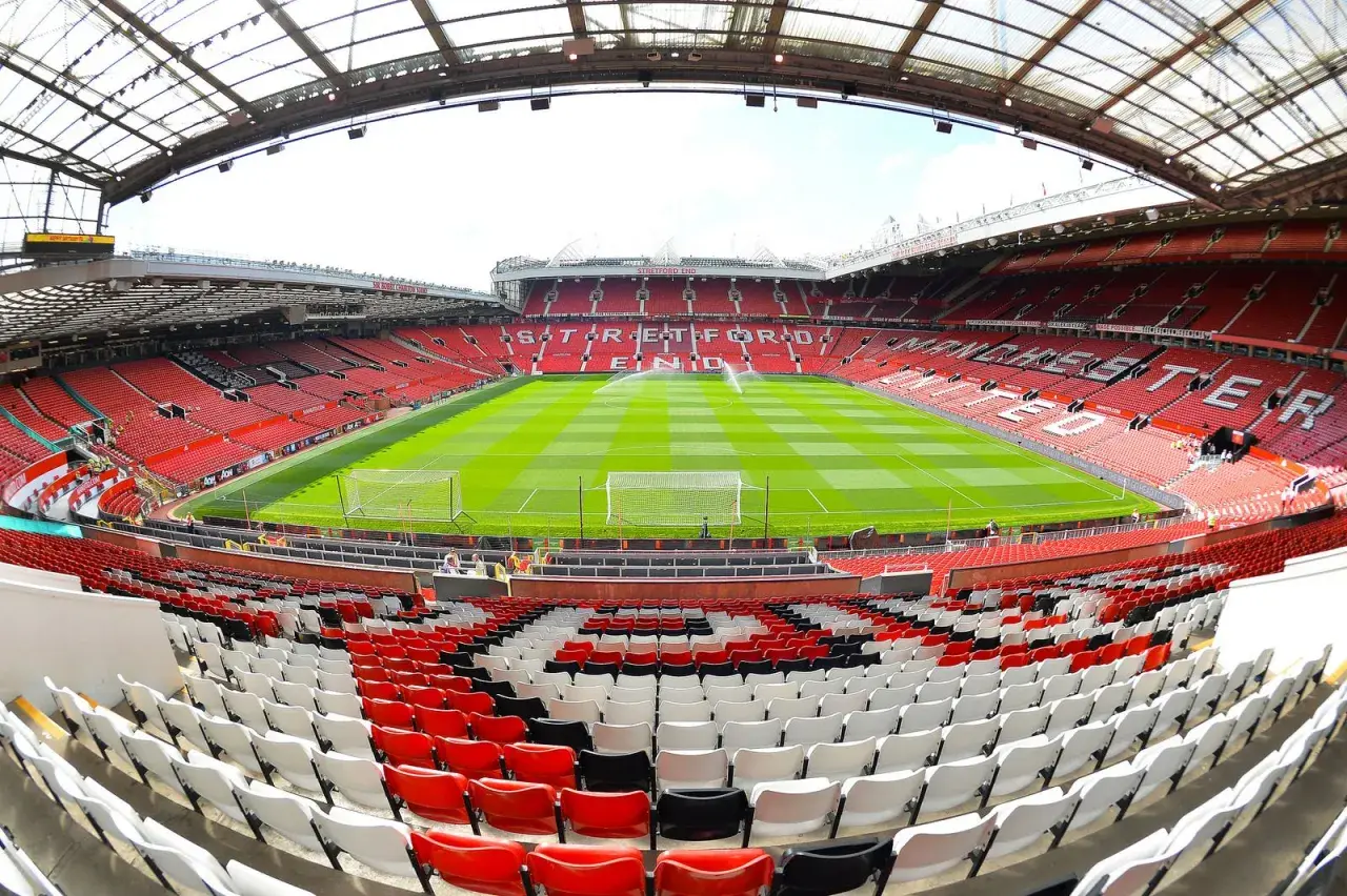 Widok na murawę i trybuny stadionu Old Trafford. Znany z imponującej pojemności, ten obiekt jest domem Manchesteru United.