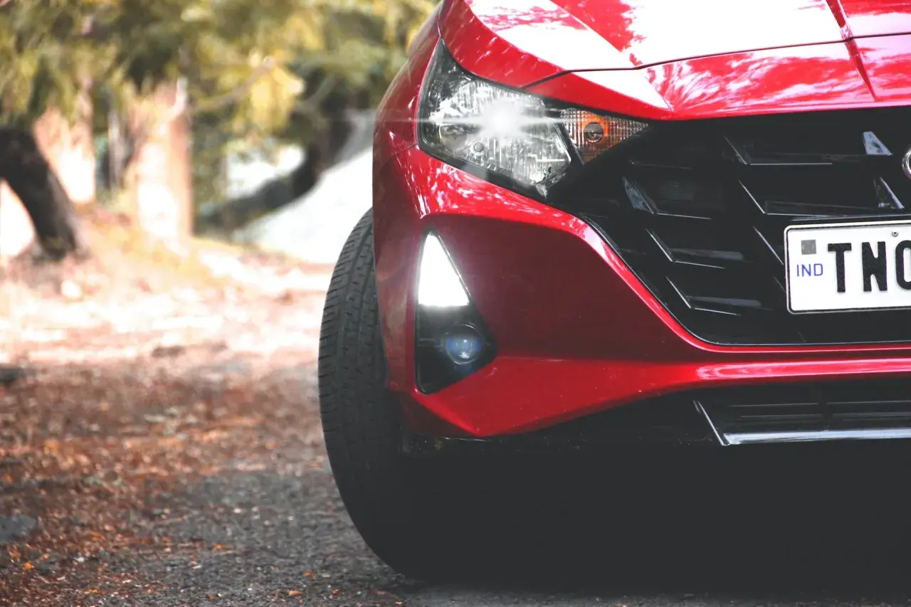 Czerwony Hyundai i20 z zapaloną żarówką do jazdy dziennej, gotowy do drogi.