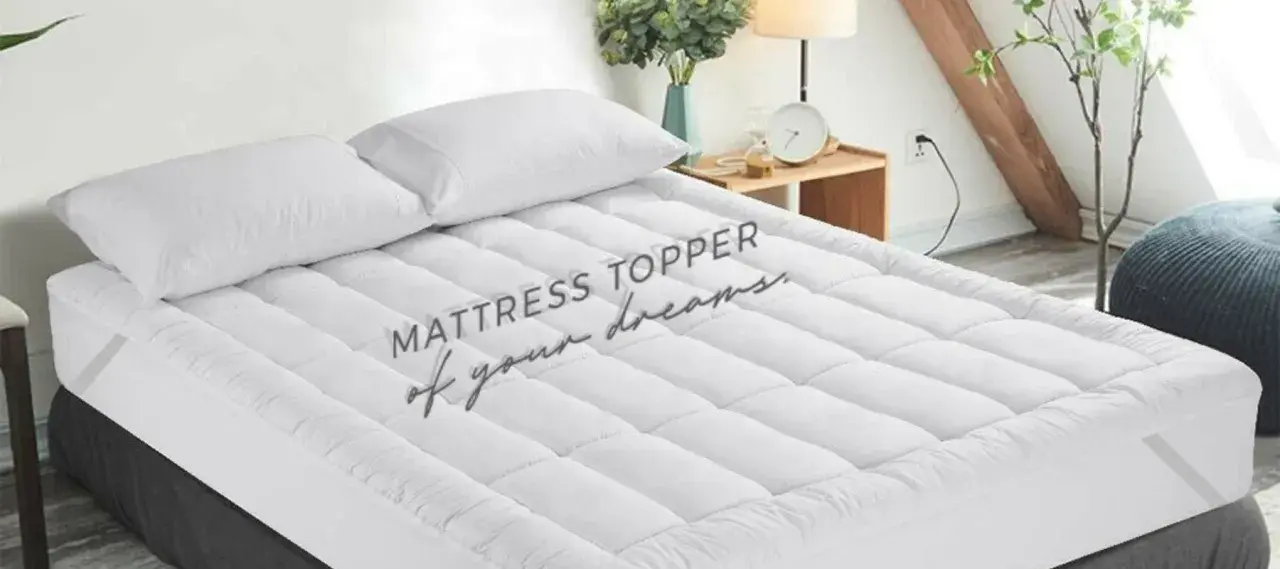 A plush mattress topper with two white pillows sits on a bed, promising a night of sweet dreams.