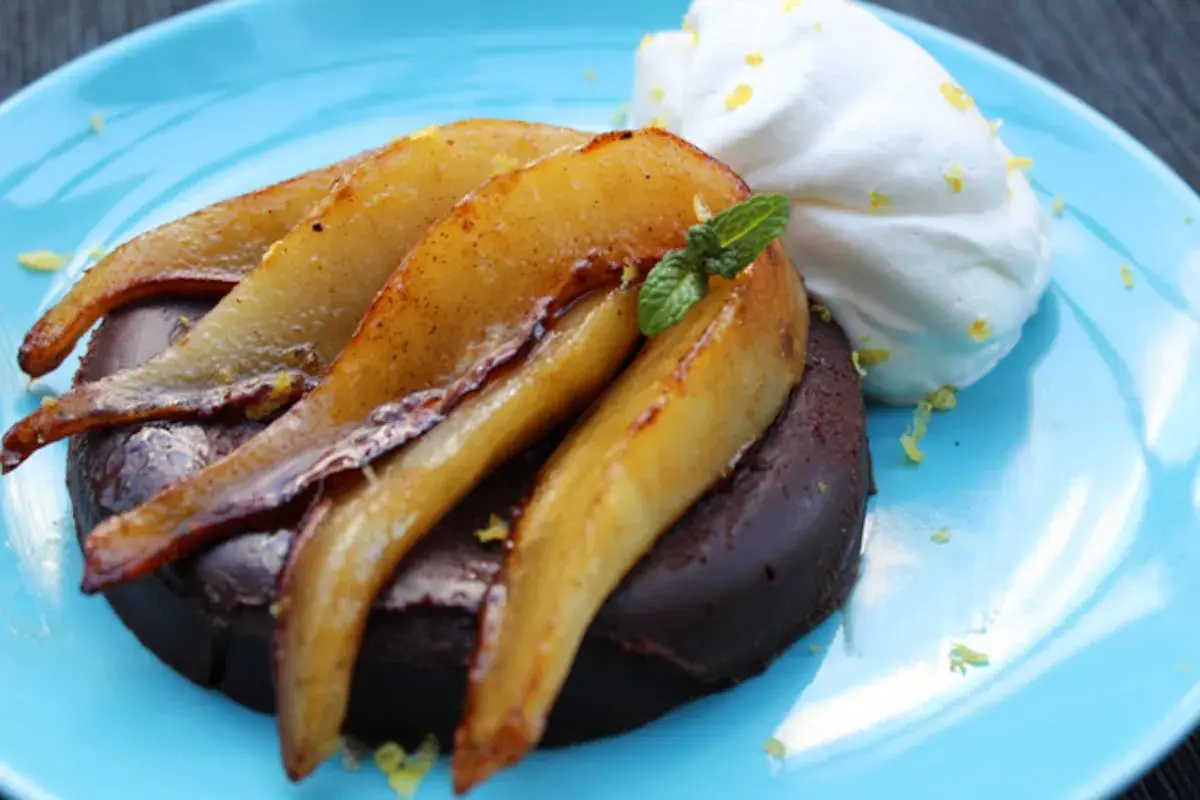 Deliciosa marquesa de chocolate con peras caramelizadas y crema batida, un postre que te hará sentir como la realeza.