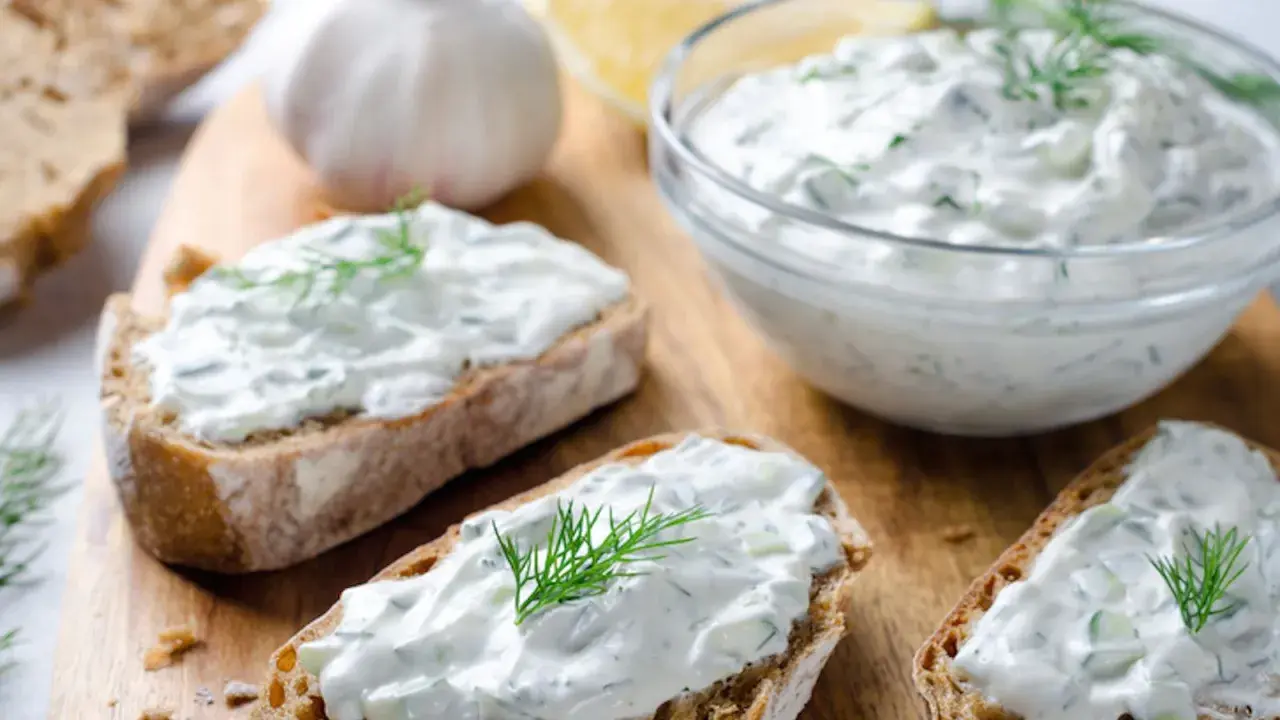 Fette di pane con salsa tzatziki, cetrioli, aglio e aneto.