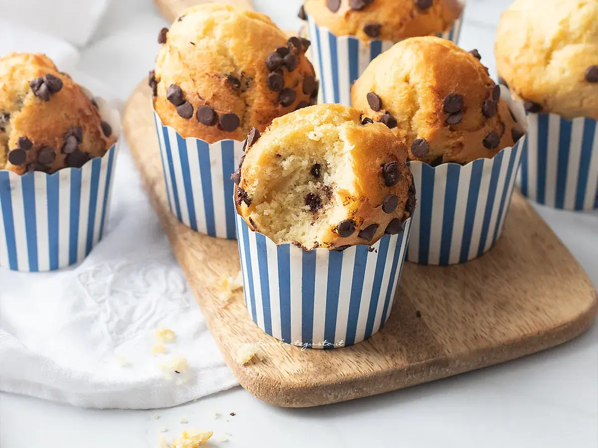 Muffin in friggitrice ad aria con gocce di cioccolato, uno è stato morso rivelando un interno soffice e goloso.