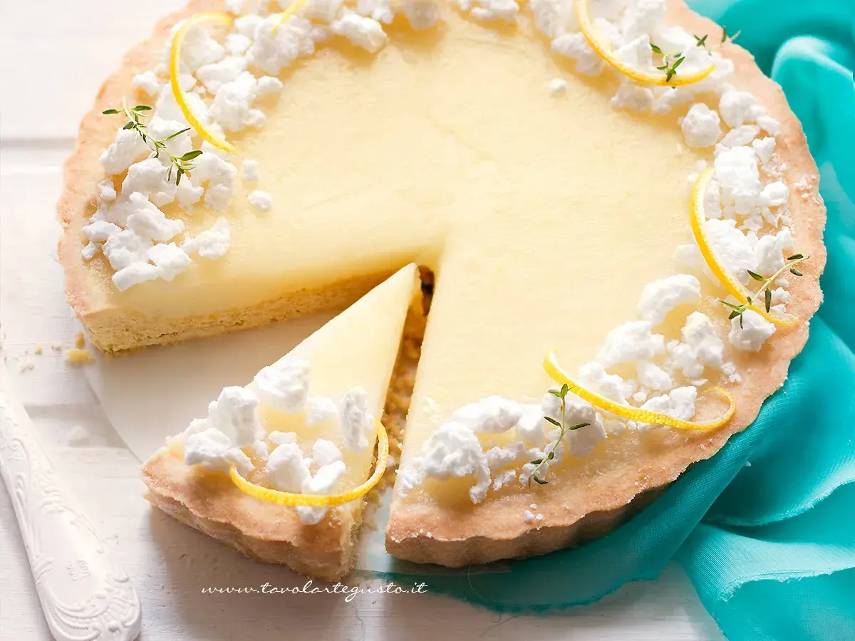 Deliziosa crostata al limone con meringhe e scorzette, una fetta è già stata servita.