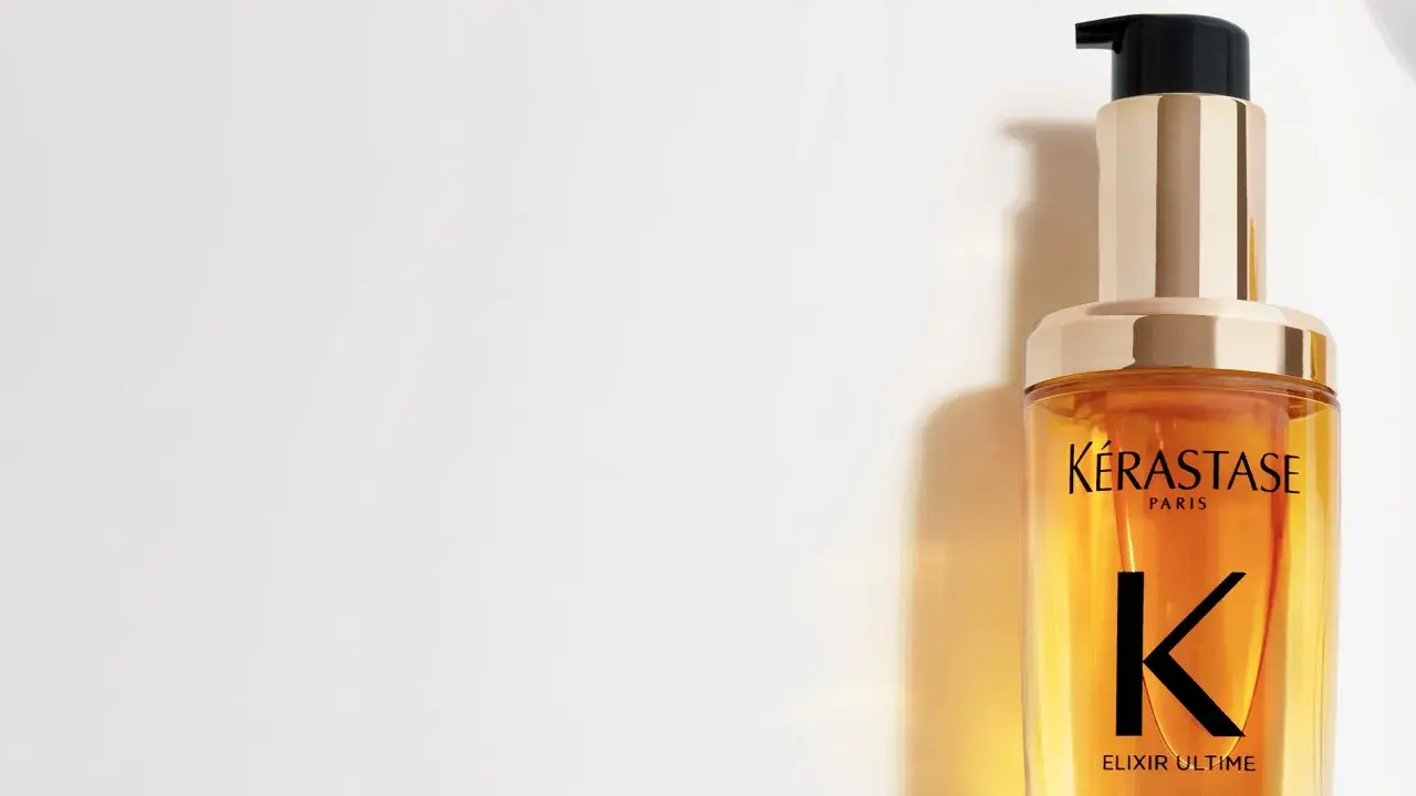 Lyxig flaska med Kérastase Elixir Ultime olja i håret. Ger glans och näring.
