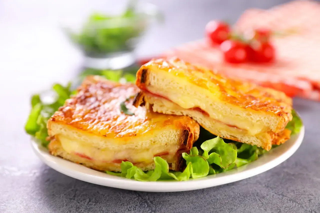 Deux croque monsieur gourmands, comme ceux de grand-mère, servis sur un lit de salade verte. Le fromage fondant et le pain doré donnent envie.