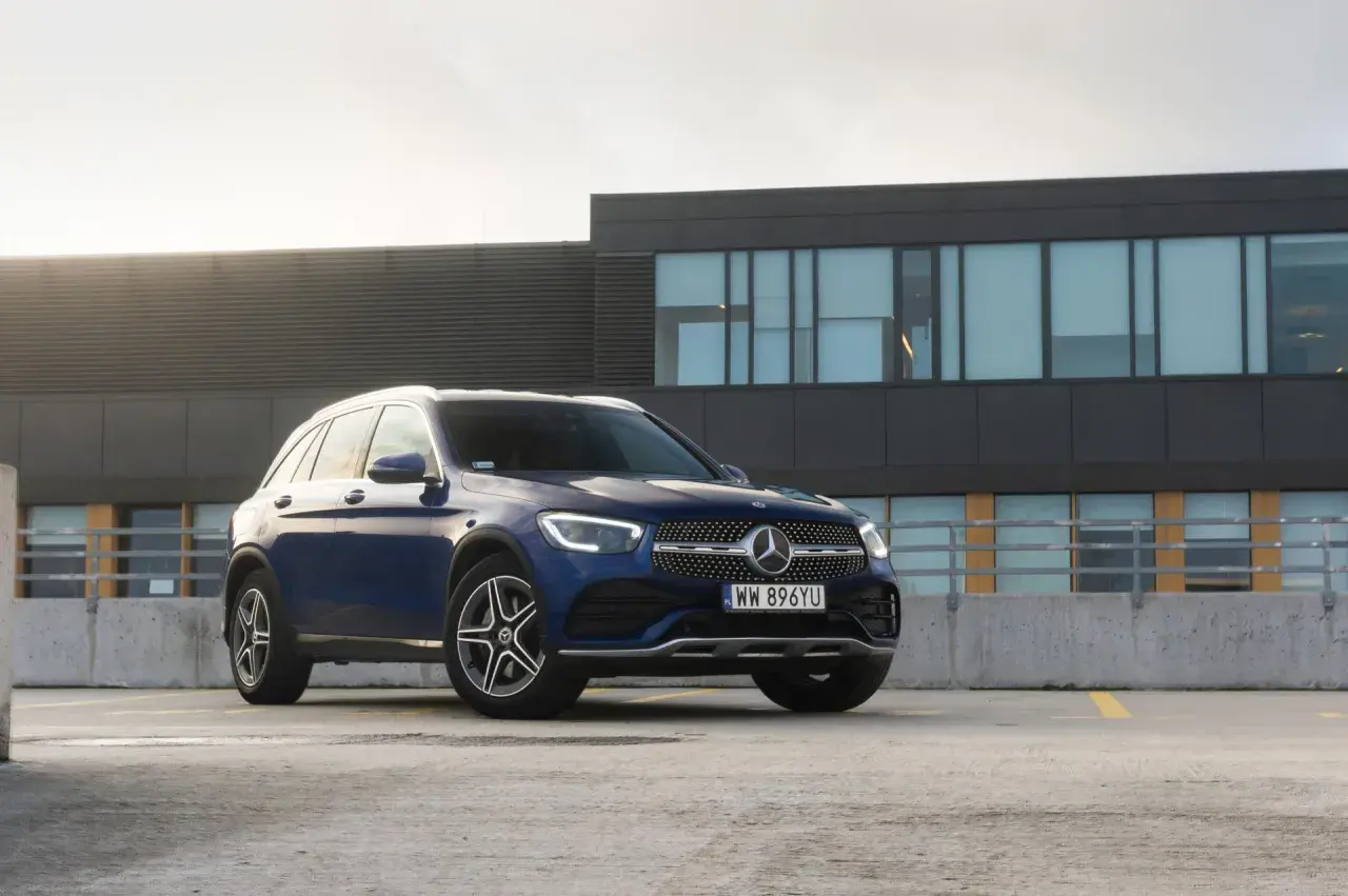 Elegancki, granatowy Mercedes GLC SUV zaparkowany na dachu budynku.