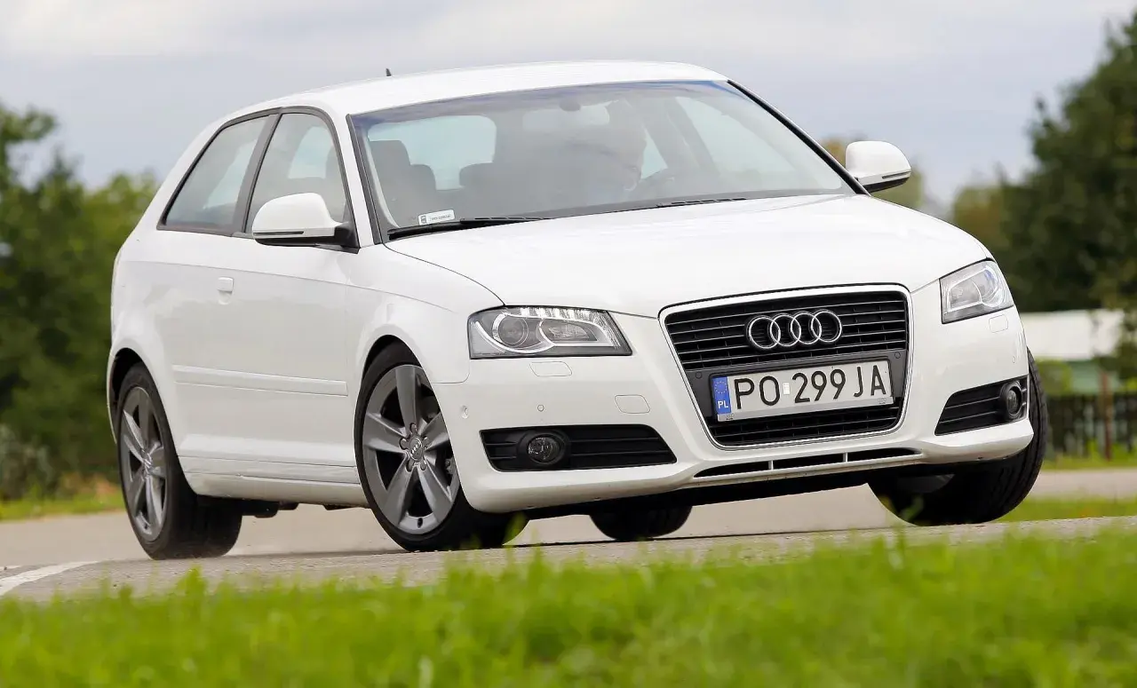Białe Audi A3 8P w ruchu, z widoczną żarówką stopu.