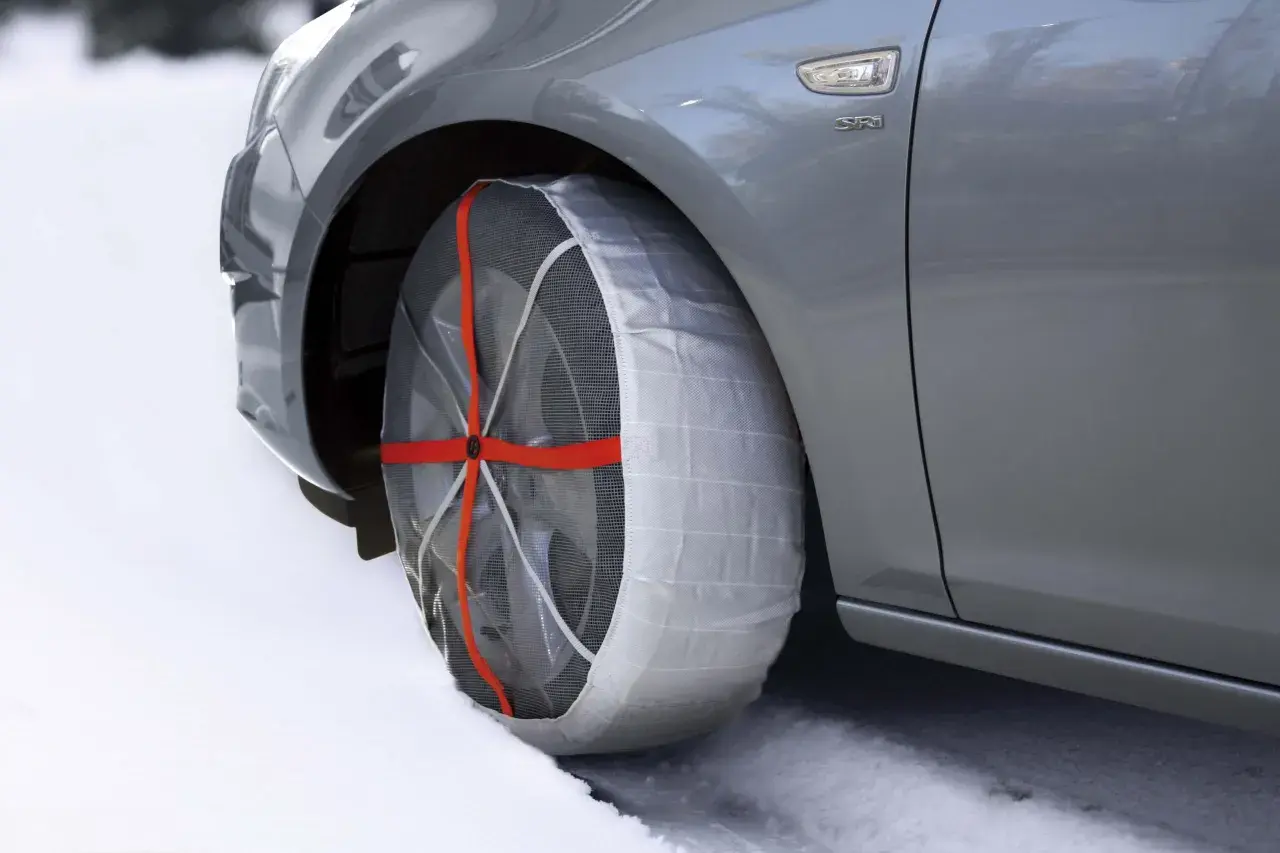 Neumático de coche con cadenas de nieve puestas, ideal para saber donde se colocan las cadenas de nieve en condiciones de hielo.
