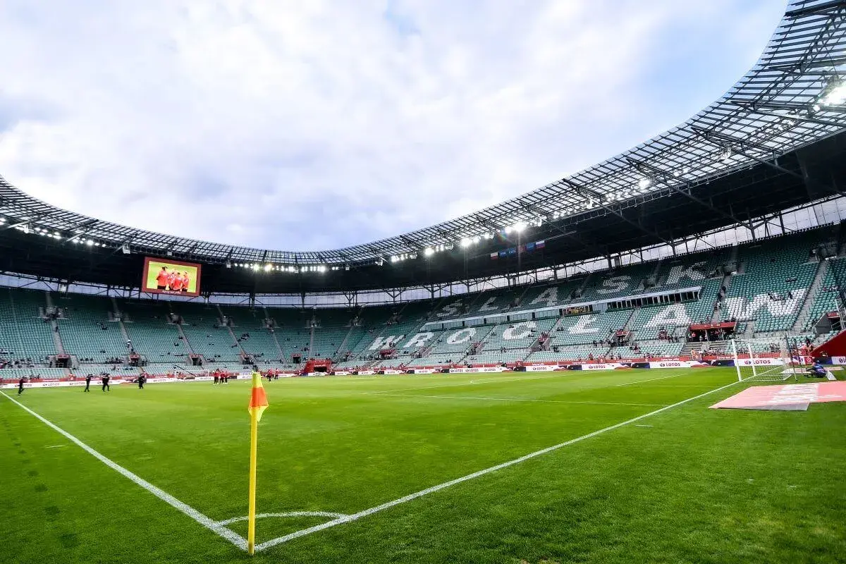 Tarczyński Arena Wrocław, z zieloną murawą i trybunami, gotowa na przyjęcie kibiców. Jej pojemność robi wrażenie.