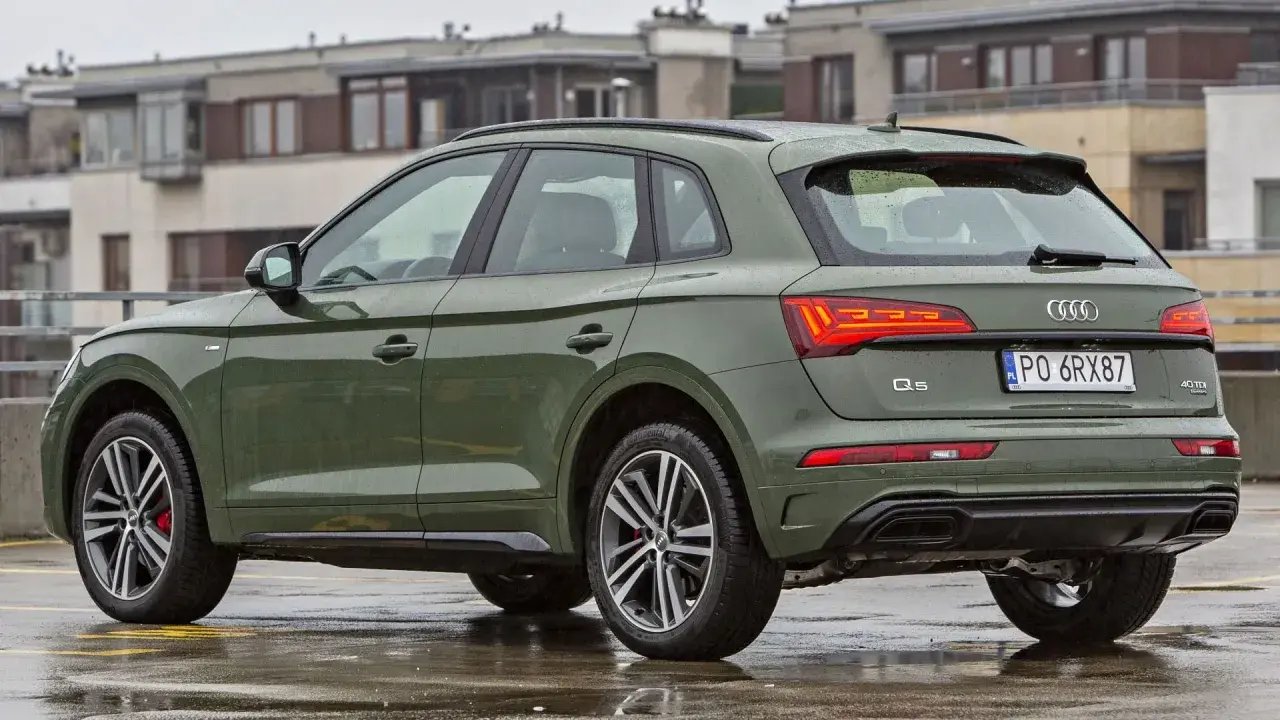 Zielony Audi Q5 na mokrym parkingu. Poznaj jego imponujące audi q5 wymiary i możliwości.