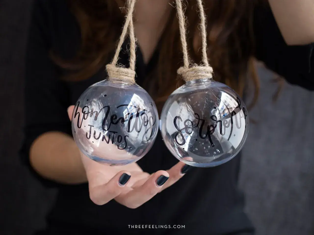 Dos bolas de navidad personalizadas con nombre, una dice "hogar" y la otra "juntos".