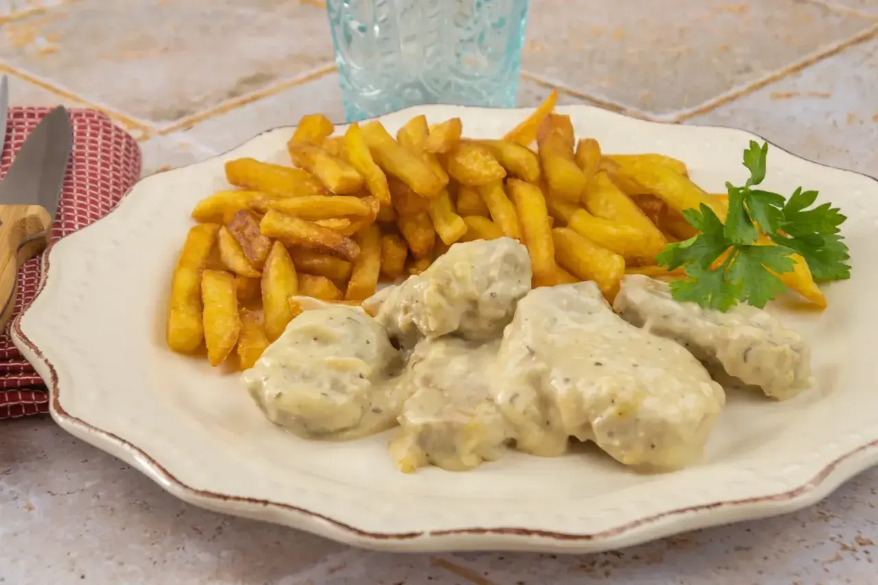 Filet mignon maroilles, tendre viande enrobée d'une sauce crémeuse, accompagnée de frites dorées et d'une touche de persil frais. Un délice !