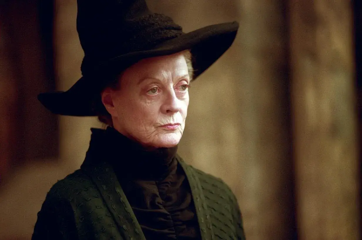 Profesor Minerwa McGonagall w czarnym kapeluszu i szacie, z surowym wyrazem twarzy, gotowa do działania.