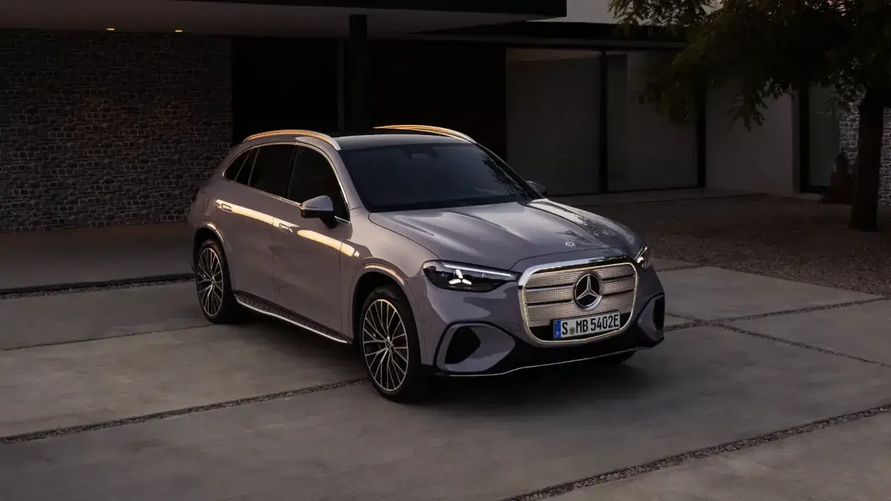 En elegant grå bil Mercedes står parkerad på en uppfart framför ett modernt hus.
