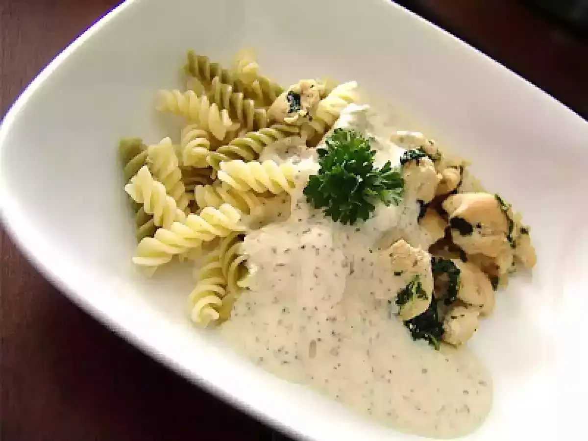 Pâtes fusilli, poulet et sauce crémeuse, garnies de persil. Un délice de pâtes pesto mozzarella.