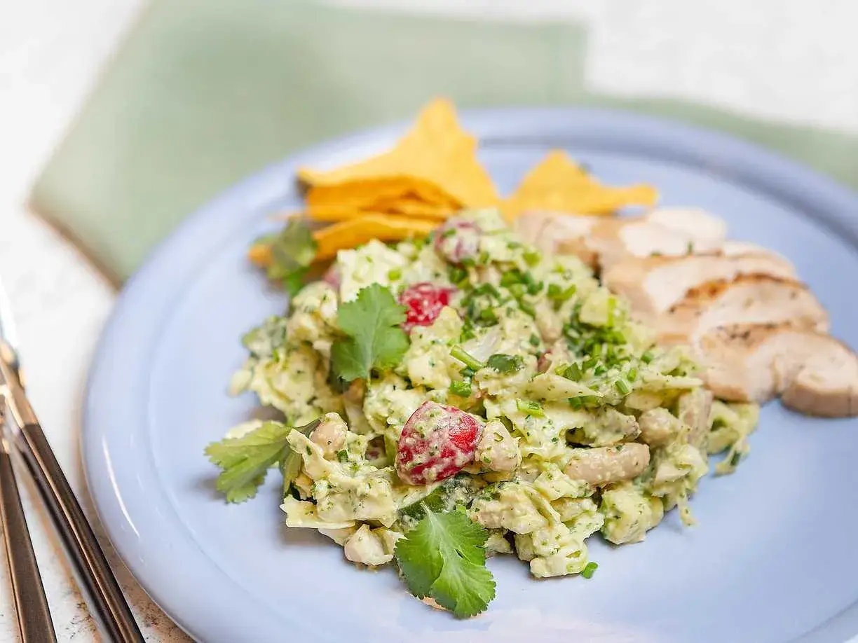 En krämig kycklingsallad med avokado och körsbärstomater, serverad med tortillachips och grillad kyckling. Ett perfekt kycklingsallad recept för en lätt lunch.