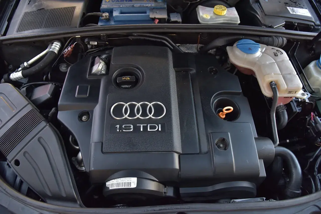 Silnik 1.9 TDI Audi z widocznym logo i oznaczeniem. Widać elementy układu chłodzenia i akumulator.