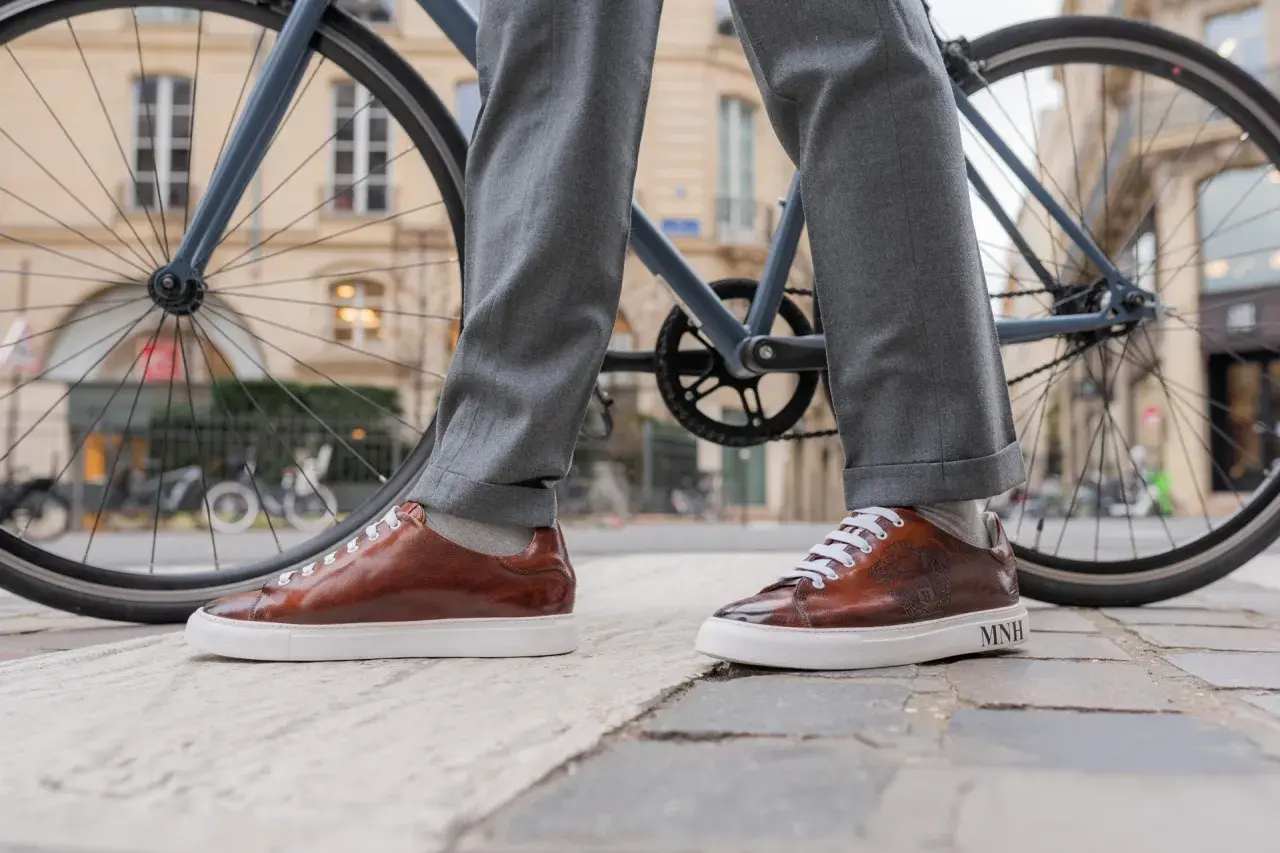 Eleganckie, brązowe sneakersy do garnituru, idealne na miejską przejażdżkę rowerem.