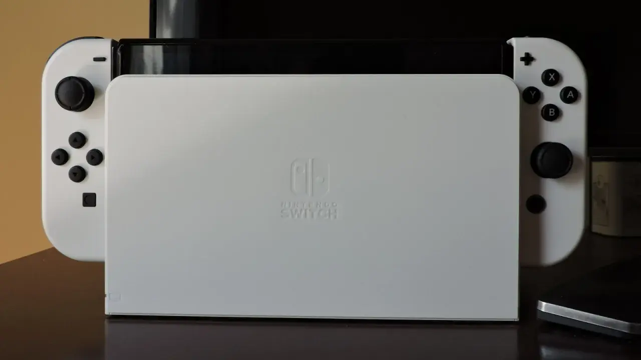 Biały Nintendo Switch z dokiem. Zastanawiasz się, czy da się podłączyć Nintendo Switch do laptopa?