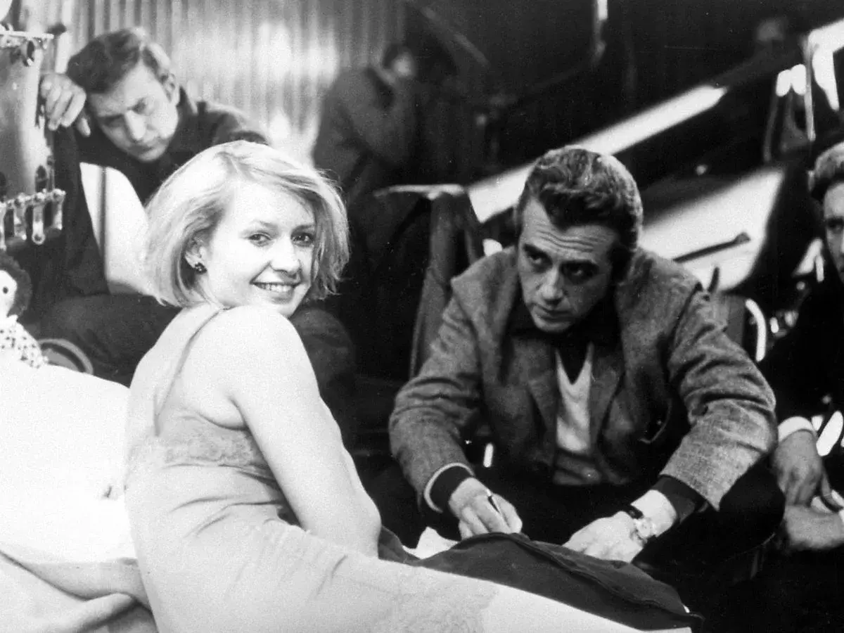 Uśmiechnięta Elżbieta Czyżewska z mężczyznami na planie filmowym. Choć nie widać dzieci, jej spojrzenie sugeruje radość i nadzieję.
