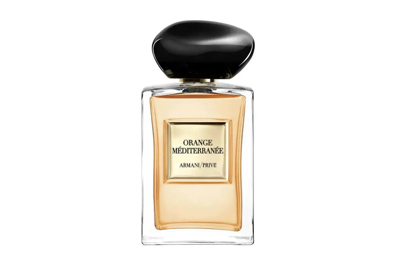 Szklana butelka z pomarańczowym płynem i czarną nakrętką. Etykieta głosi "ORANGE MÉDITERRANÉE ARMANI/PRIVE".