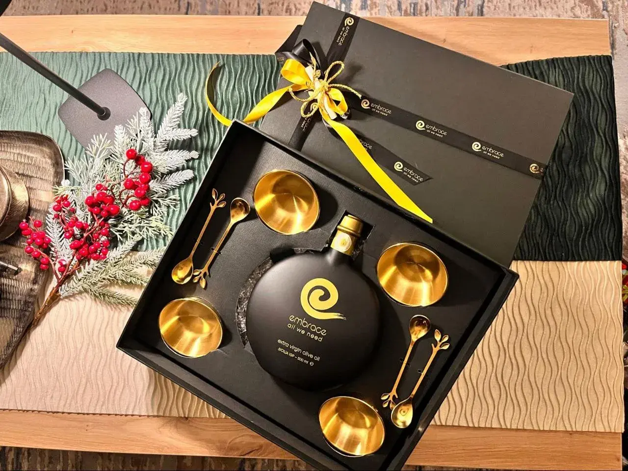 Elegante confezione regalo con olio d'oliva extra vergine, coppette e cucchiaini dorati. Regalare olio d'oliva ha un significato di benessere e cura.